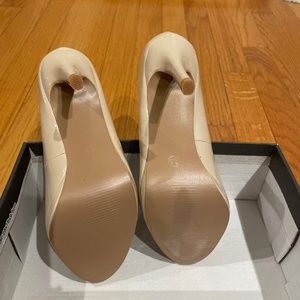 Nude color patent leather spiked peep toe pumps